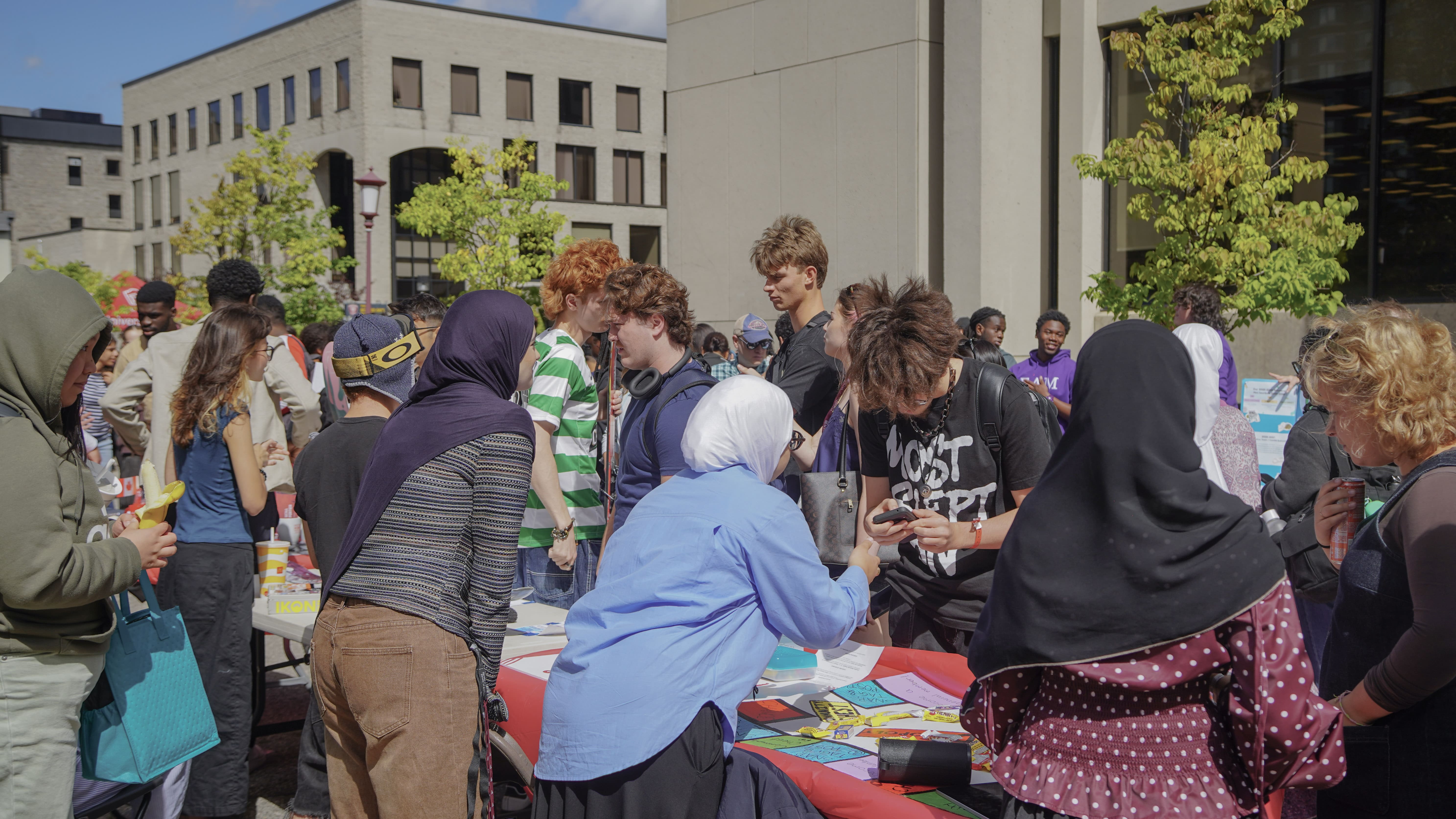Des étudiants regroupés autour d'une table lors de la foire des clubs.